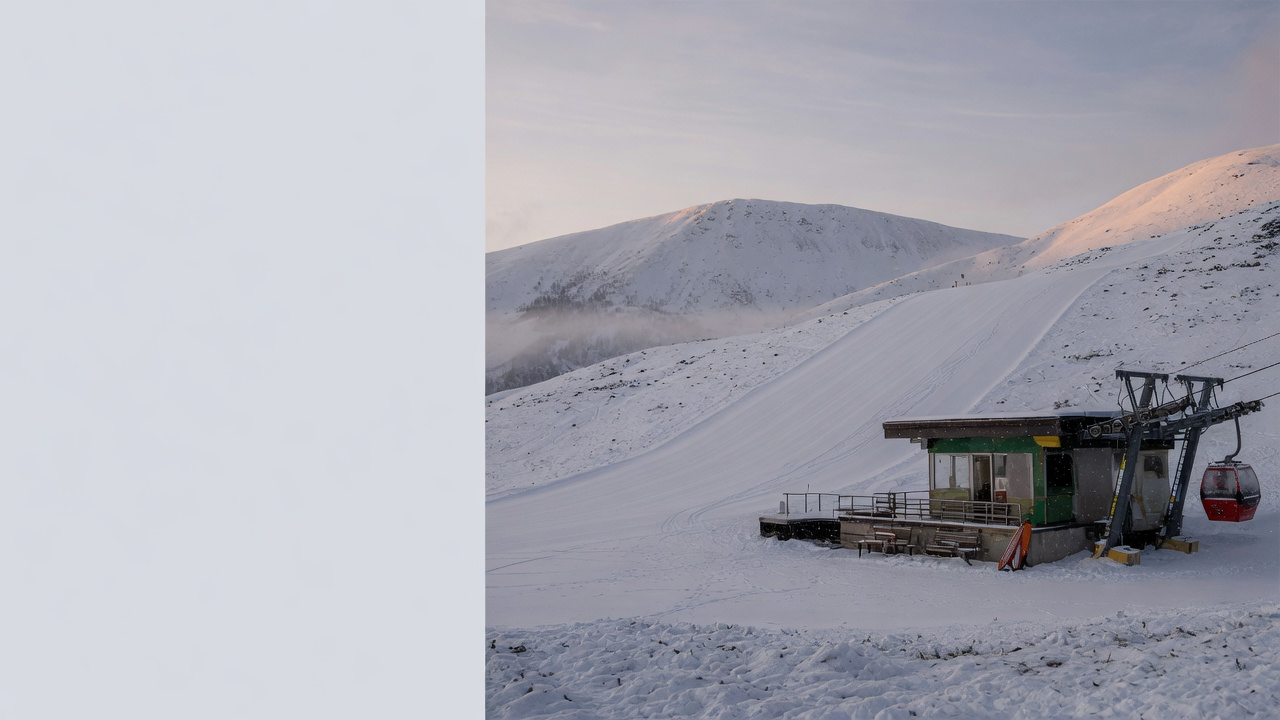 AI-generated editorial image: Empty alpine ski lift terminal and snowy mountain slope in early morning light