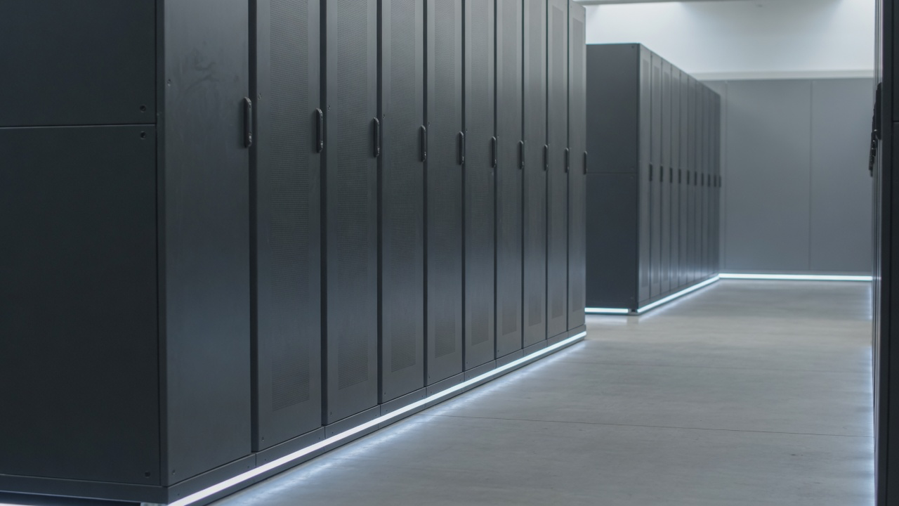 AI-generated editorial image: An enterprise data center corridor with brushed-metal server racks and soft floor lighting.